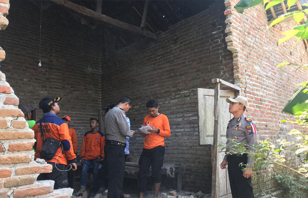 Kapolsek Tempurejo AKP. Hartanto bersama anggota dan BPBD saat mengecek kondisi rumah warganya yang temboknya jebol akibat gempa. (foto : istimewa / Jatim TIMES)