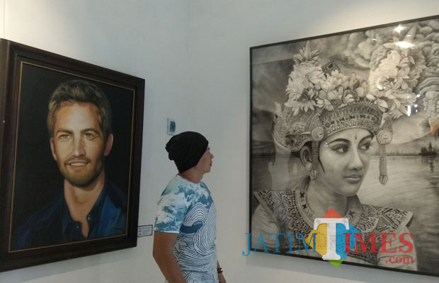 Pengunjung melihat lukisan yang ditampilkan dalam pameran Terang Bagimu Kawan di Dewan Kesenian Malang. (Foto: Nurlayla Ratri/MalangTIMES)