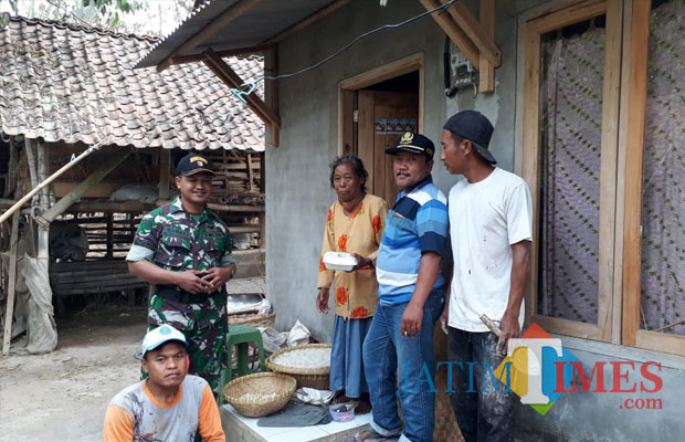 Kepala Dusun Sentong Baitul Aziz (pakai kaus bergaris) bersama babinsa dan anggota komunitas membagikan nasi kotak kepada warga. (foto : Moh. Ali Makrus / Jatim TIMES)