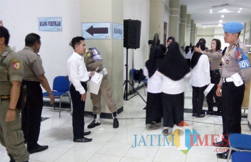Petugas keamanan dari Polres Jember dan Satpol PP saat memeriksa peserta test CPNS sebelum memasuki ruang isolasi (foto : Moh. Ali Makrus / Jatim TIMES)
