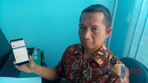 Kabid PIAK Dispendukcapil Pemkab Blitar Imam Maini menunjukkan cara pengurusan e-KTP melalui ponsel android.(Foto : Aunur Rofiq/BlitarTIMES)