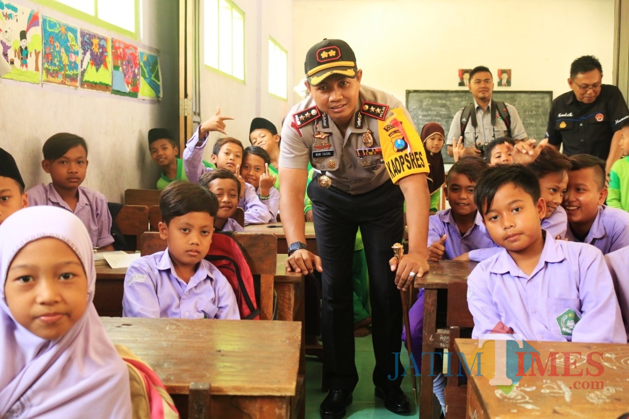 Kapolres Kediri AKBP Roni Faisal ketika berfoto bersama pelajar seusai memberikan pembekalan bahaya narkoba. (Foto: B. Setioko/JatimTIMES)
