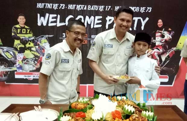 Wawali Kota Batu Punjul Santoso (kiri) bersama Kapolres Batu AKBP Budi Hermanto (kanan) merangkul seorang anak yatim piatu penerima santunan. (Foto: Muklas/BatuTIMES)