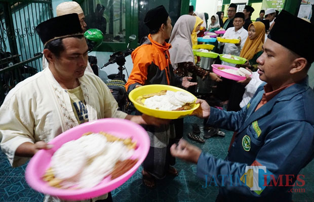 Para santri ketika membagikan nasi liwet kepada seluruh jamaah yang hadir. (Foto: B. Setioko/JatimTIMES)