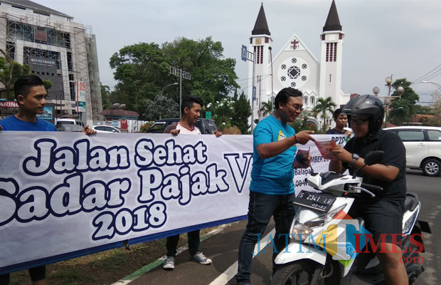 Sejumlah petugas melakukan sosialisasi kegiatan Gebyar Jalan Sehat Sadar Pajak V 2018 yang diselenggarakan BP2D Kota Malang. (Foto: Nurlayla Ratri/MalangTIMES)