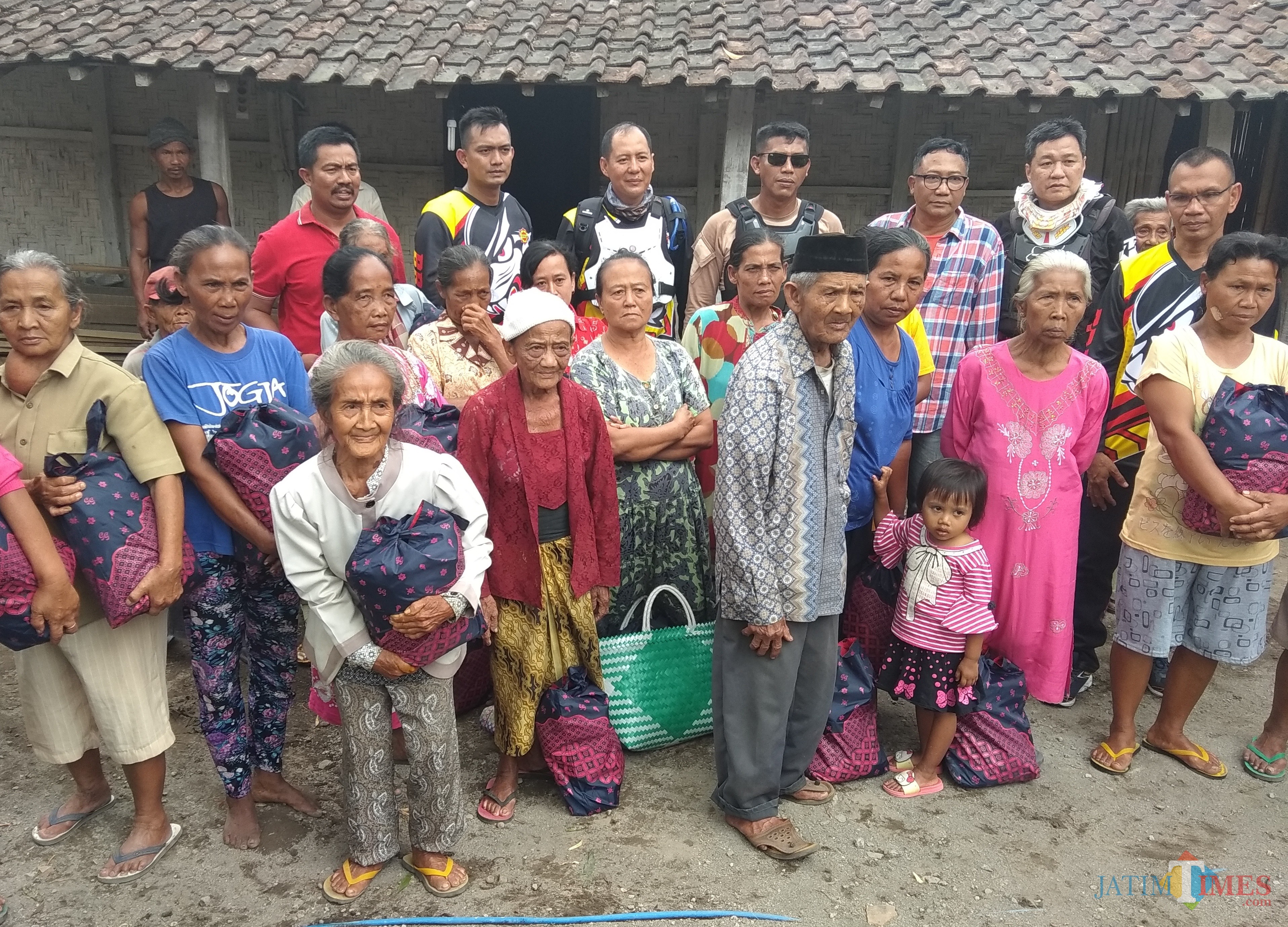Para rider bagikan sembako kepada warga yang kurang mampu di sela sela latihan bersama. (eko Arif s /JatimTimes)
