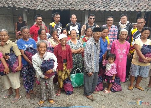 Para rider bagikan sembako kepada warga yang kurang mampu di sela sela latihan bersama. (eko Arif s /JatimTimes)