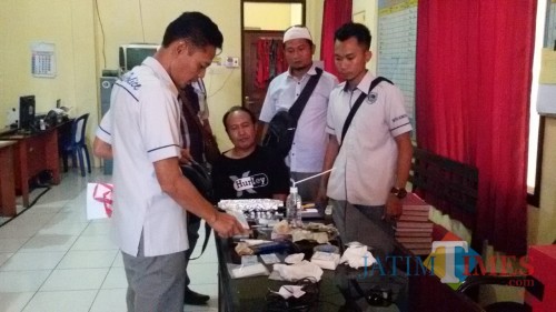 Pelaku (kaus hitam) bersama barang bukti saat berada di ruangan Satnarkoba Polres Situbondo. (Foto Heru Hartanto/Situbondo TIMES)