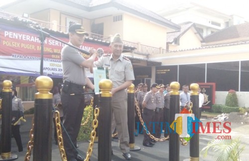 Kapolres Jember AKBP Kusworo Wibowo saat menerima sertifikat dari Kepala BPN Jember Didik Bangun Restu Aji SH di halaman Mapolres Jember. (foto : Moh. Ali Makrus / Jatim TIMES)