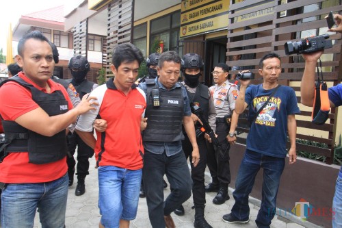 Pelaku pembacokan dikawal polisi. (Agus Salam.Jatim TIMES)