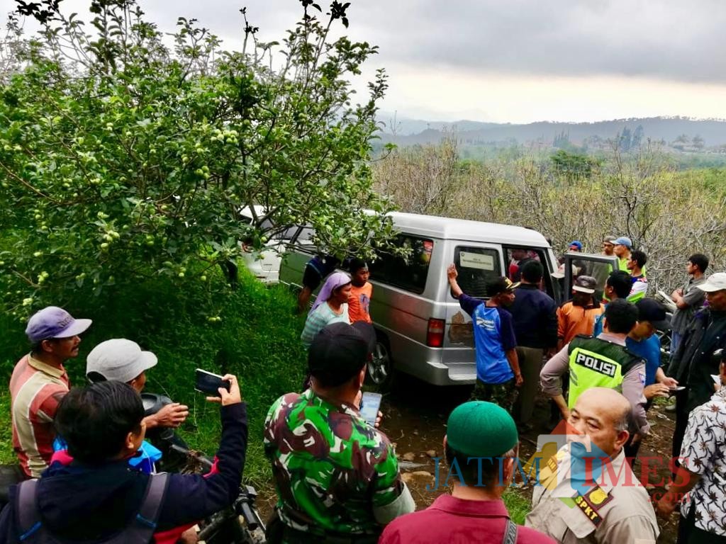 Masyarakat sekitar memadati mobil jenazah Sigit di lahan perkebunan apel di Desa Sumbergondo Kecamatan Bumiaji, Selasa (4/12/2018). (Foto: Irsya Richa/MalangTIMES)