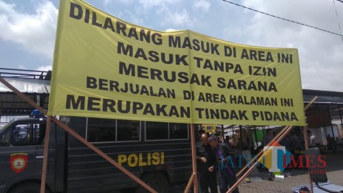 Sebuah spanduk larangan berjualan di sekitar lahan sengketa di Jalan Sudiro, Kota Batu. (Foto: Nurlayla Ratri/MalangTIMES)