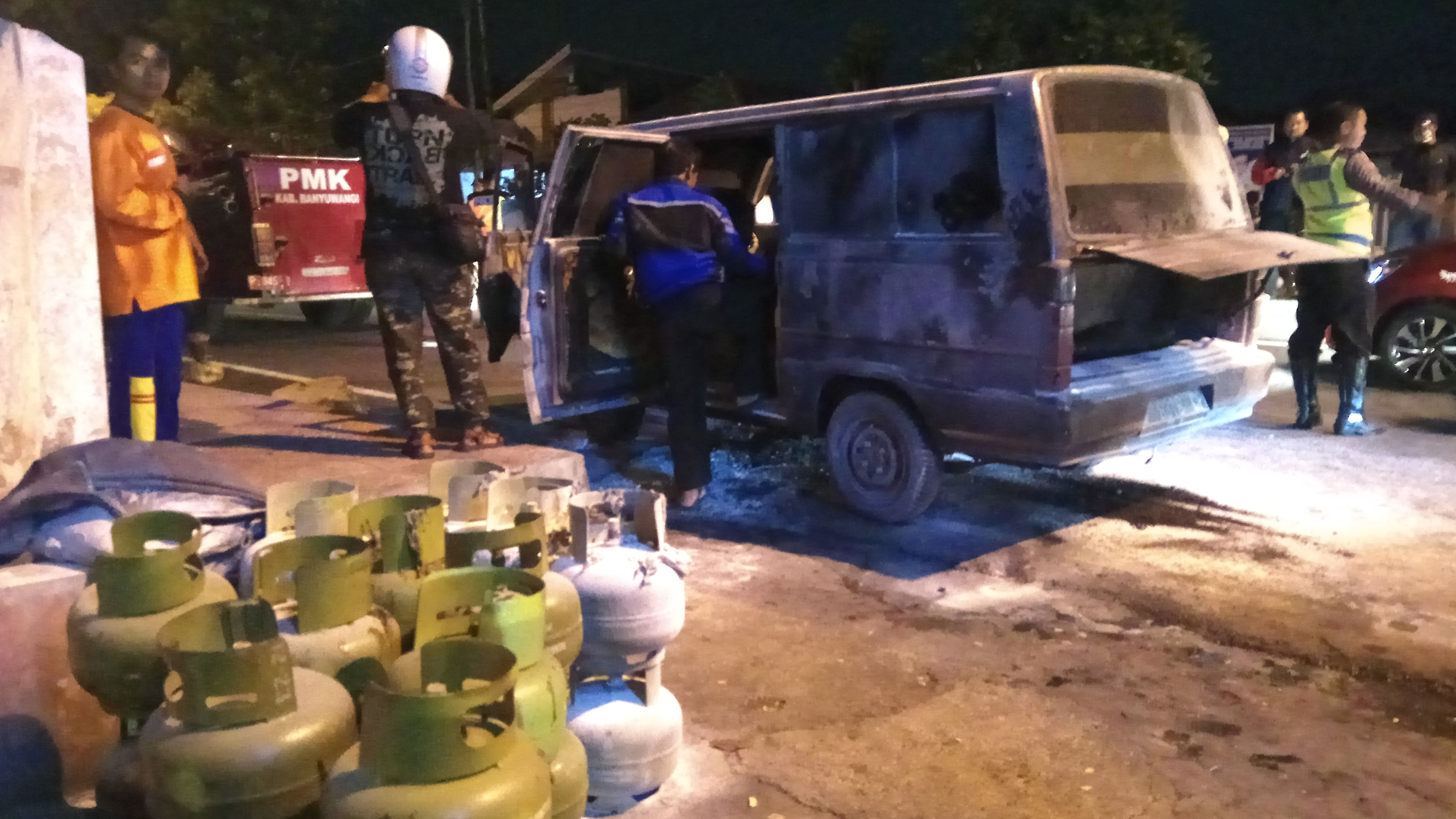 Petugas memeriksa mobil carry yang terbakar dan tumpukan gas elpiji 3 kg yang sudah dikeluarkan dari mobil