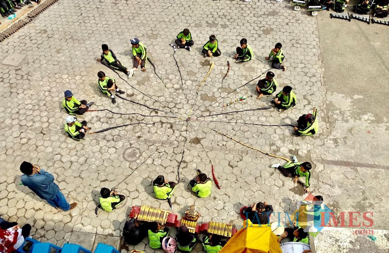 Formasi 19 pelajar dengan Cemeti Amar Rasuli di halaman sekolah MI Darul Ulum Jl Lahor Desa Pesanggarahan Kecamatan Batu, Sabtu (8/12/2018). (Foto: Irsya Richa/MalangTIMES)