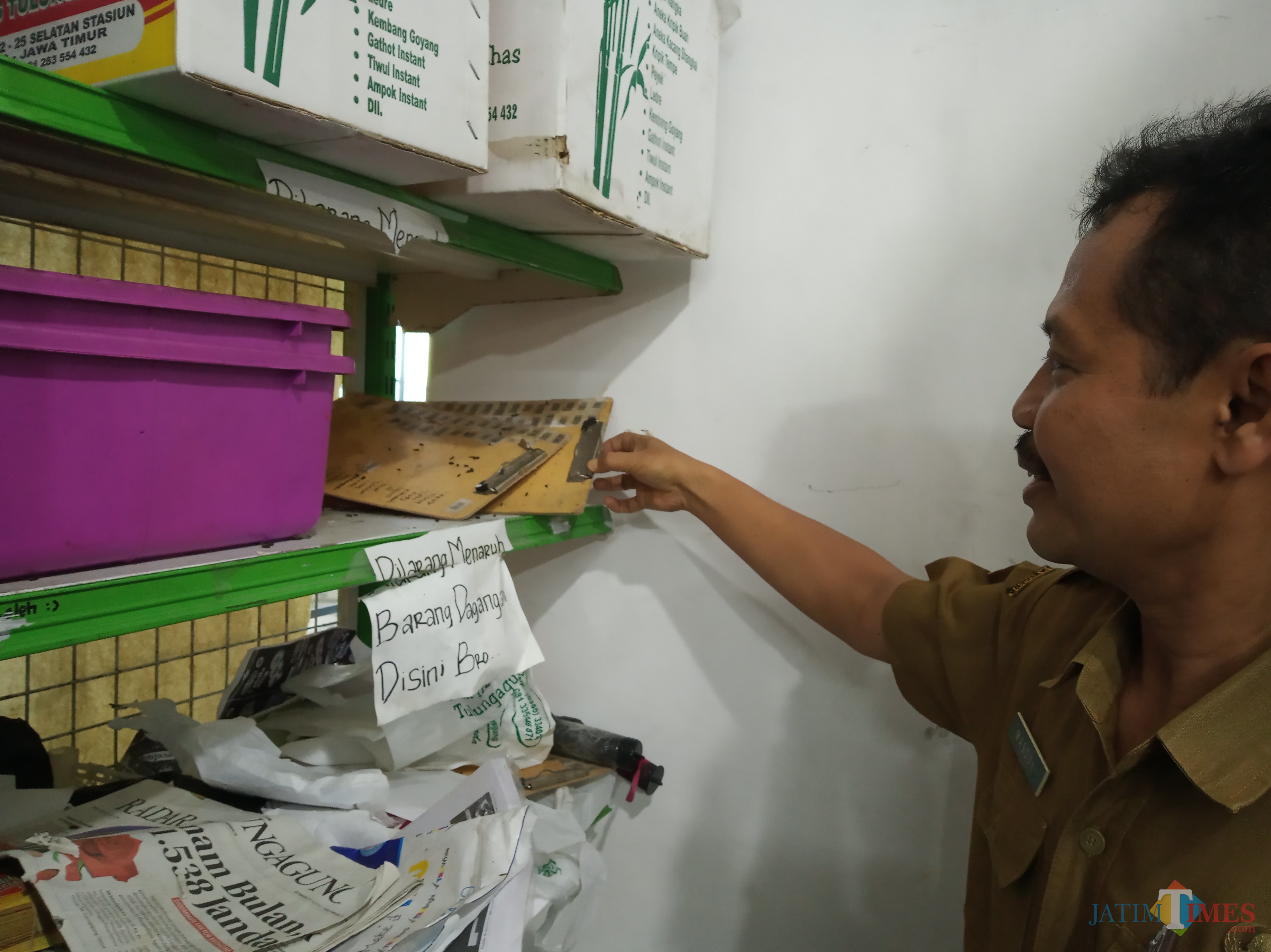 Masduki tunjukan kotoran tikus dan serangga di salah satu rak (foto: Joko Pramono/JatimTIMES)