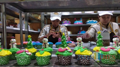 Para pekerja di Citra Kendedes Cake and Bakery tengah menghias cupcake dengan karakter-karakter khas Natal. (Foto: Nurlayla Ratri/MalangTIMES)