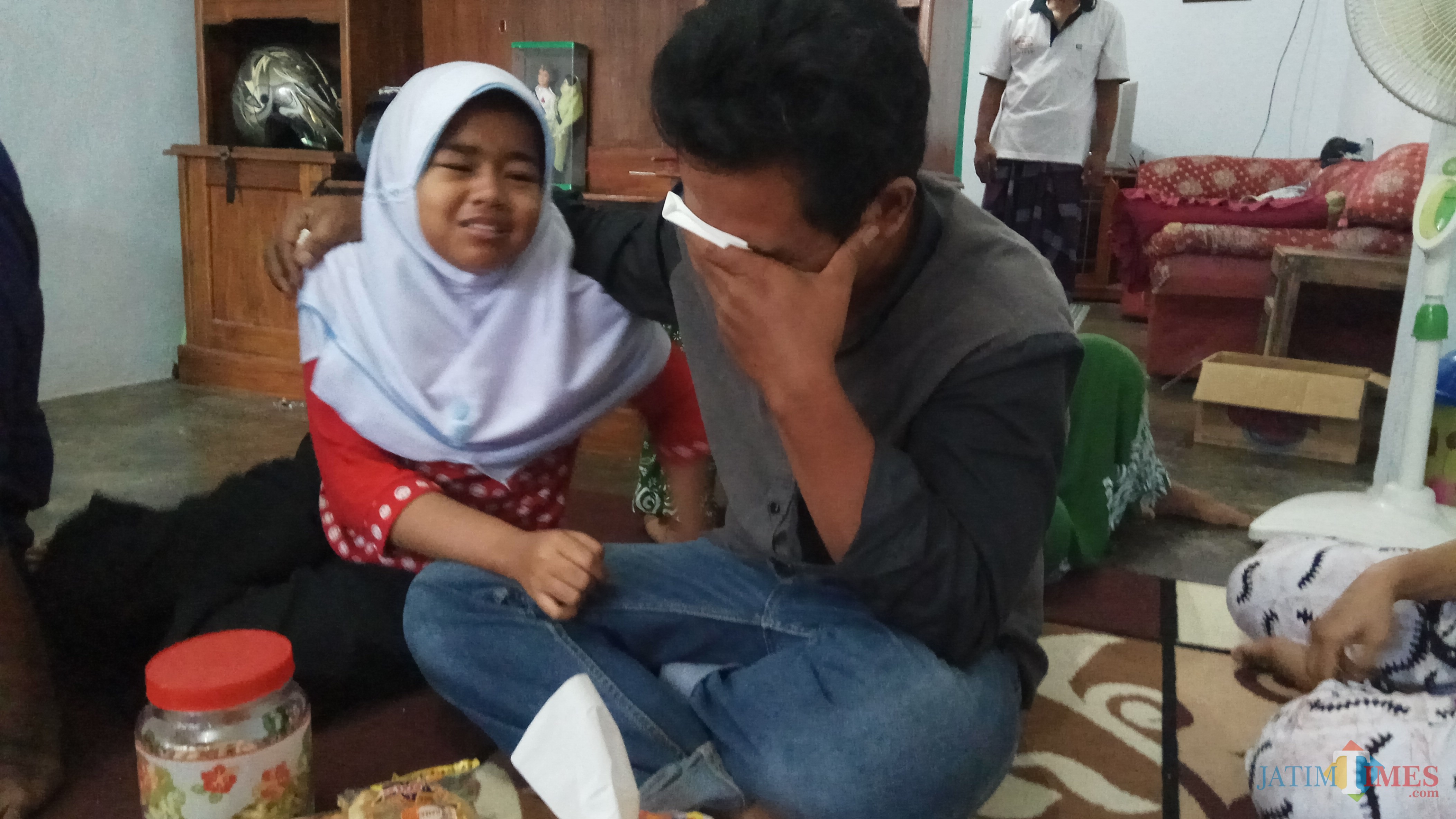 Ilham bersama anak sulungnya, Nafiza Izzati, menangis saat ditemui di rumahnya.