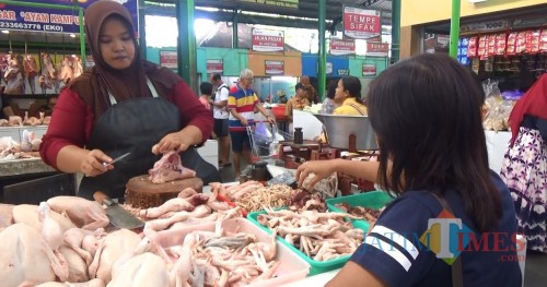 Pedagang ayam di Pasar Oro-Oro Dowo, Kota Malang tengah melayani pembeli. (Foto: Nurlayla Ratri/MalangTIMES)