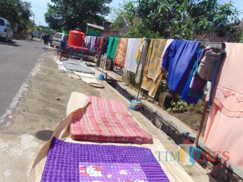 Warga menjemur kasus yang sempat terendam air selama banjir (Foto : Moch. R. Abdul Fatah / Jatim TIMES)