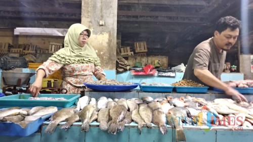 Pedagang ikan di Pasar Besar Kota Malang saat melayani pembeli di tengah melambungnya harga ikan. (Foto: Nurlayla Ratri/MalangTIMES)