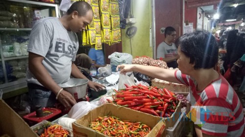 Penjual bumbu dapur di Pasar Besar Malang tengah melayani pembeli. (Foto: Nurlayla Ratri/MalangTIMES)