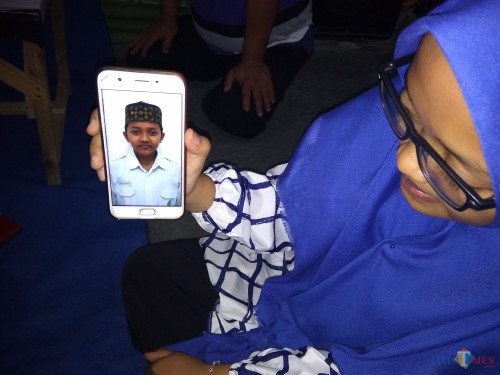 Siti Iswatun kakak korban saat menunjukkan foto adiknya. (Eko Arif S /JatimTIMES)