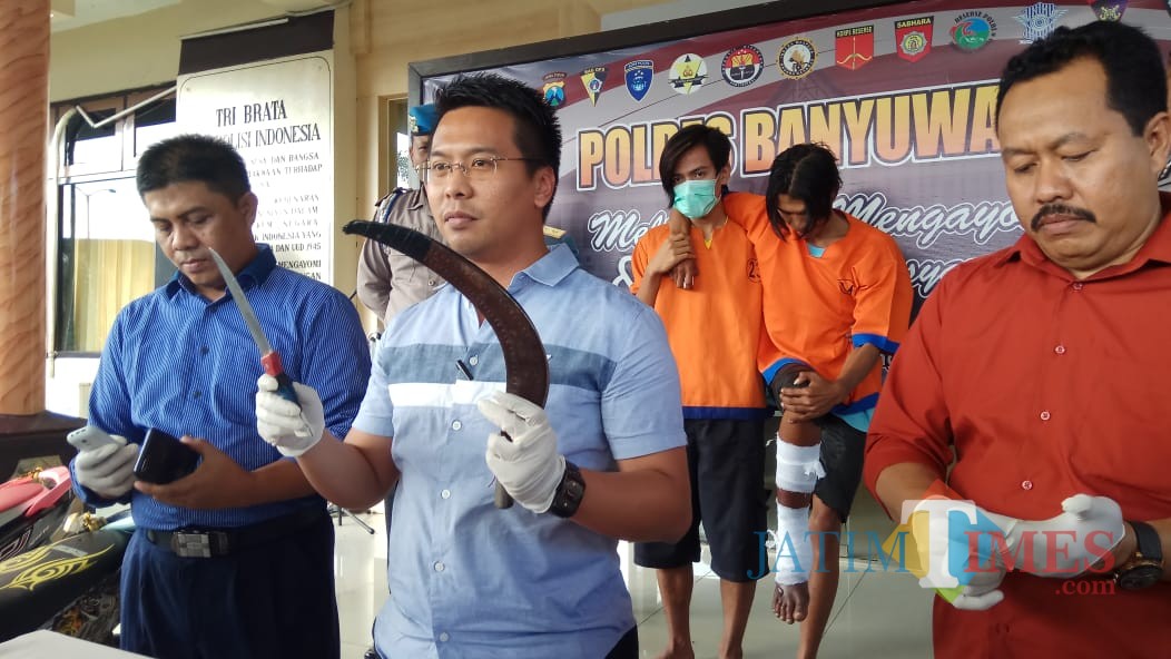 Kasat Reskrim Polres Banyuwangi AKP Panji Prathista Wijaya (tengah) menunjukan celurit yang digunakan tersangka saat beraksi, Selasa (8/1/2019) (Foto : Muhammad Hujaini/BanyuwangiTIMES)
