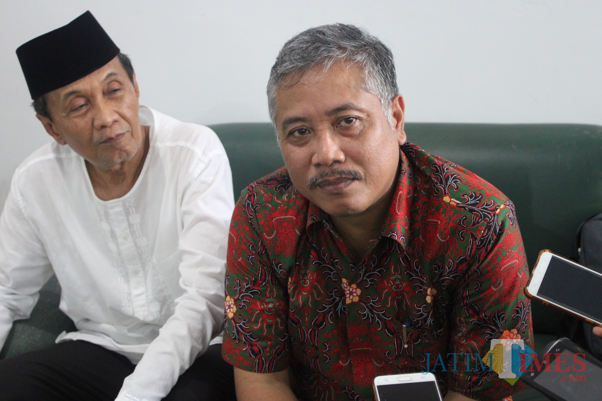 mengenakan kemeja batik berwarna merah, kuasa hukum yayasan Undar Jombang, Sholikin Rusli saat diwawancarai sejumlah awak media. (Foto : Adi Rosul / JombangTIMES)
