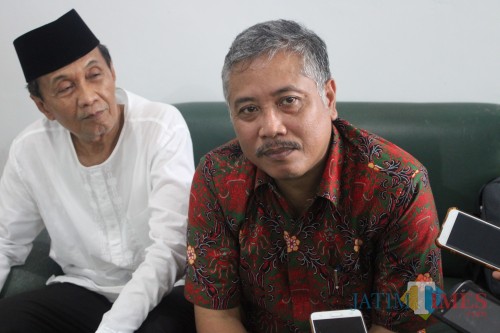 mengenakan kemeja batik berwarna merah, kuasa hukum yayasan Undar Jombang, Sholikin Rusli saat diwawancarai sejumlah awak media. (Foto : Adi Rosul / JombangTIMES)