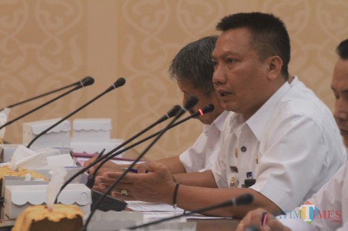 Camat Kedopok Imam Cahyadi saat menenyakan juklak dan juknis dana kelurahan pada rakor dengan komisi 1 (Agus Salam/Jatim TIMES)
