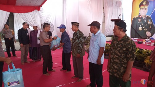 Kapolres saat memberikan bingkisan kepada tukang becak. (foto : Joko Pramono /Jatimtimes)