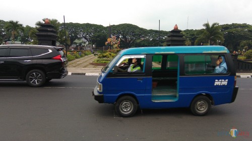 Ilustrasi sebuah angkot yang melintas di depan Balai Kota Malang tampak lengang dengan sedikit penumpang. (Foto: Nurlayla Ratri/MalangTIMES)