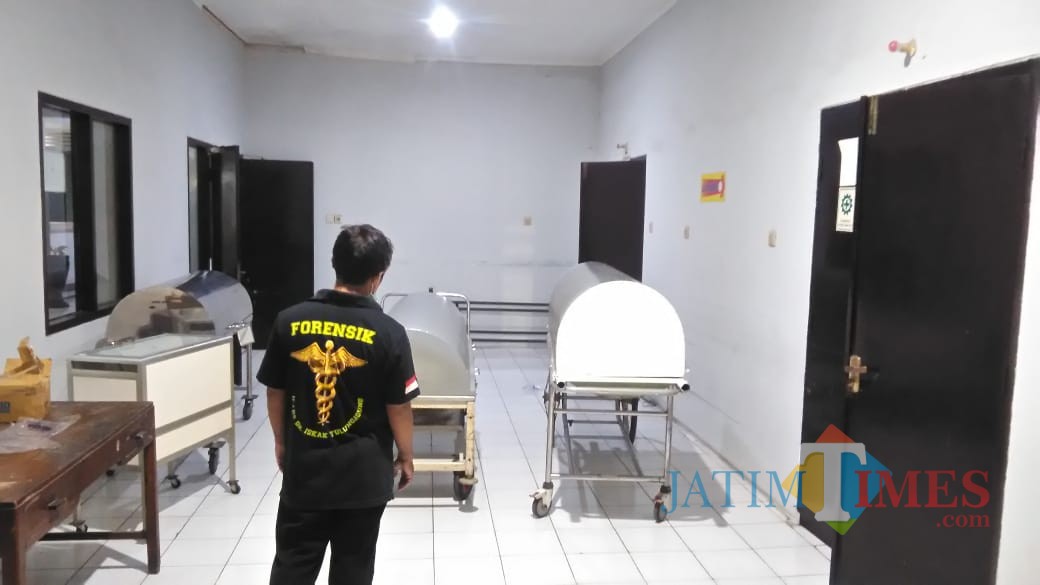 Petugas forensik sesaat setelah melakukan autopsi terhadap bayi yang dibuang dalam kloset (foto : Joko Pramono / Jatimtimes)