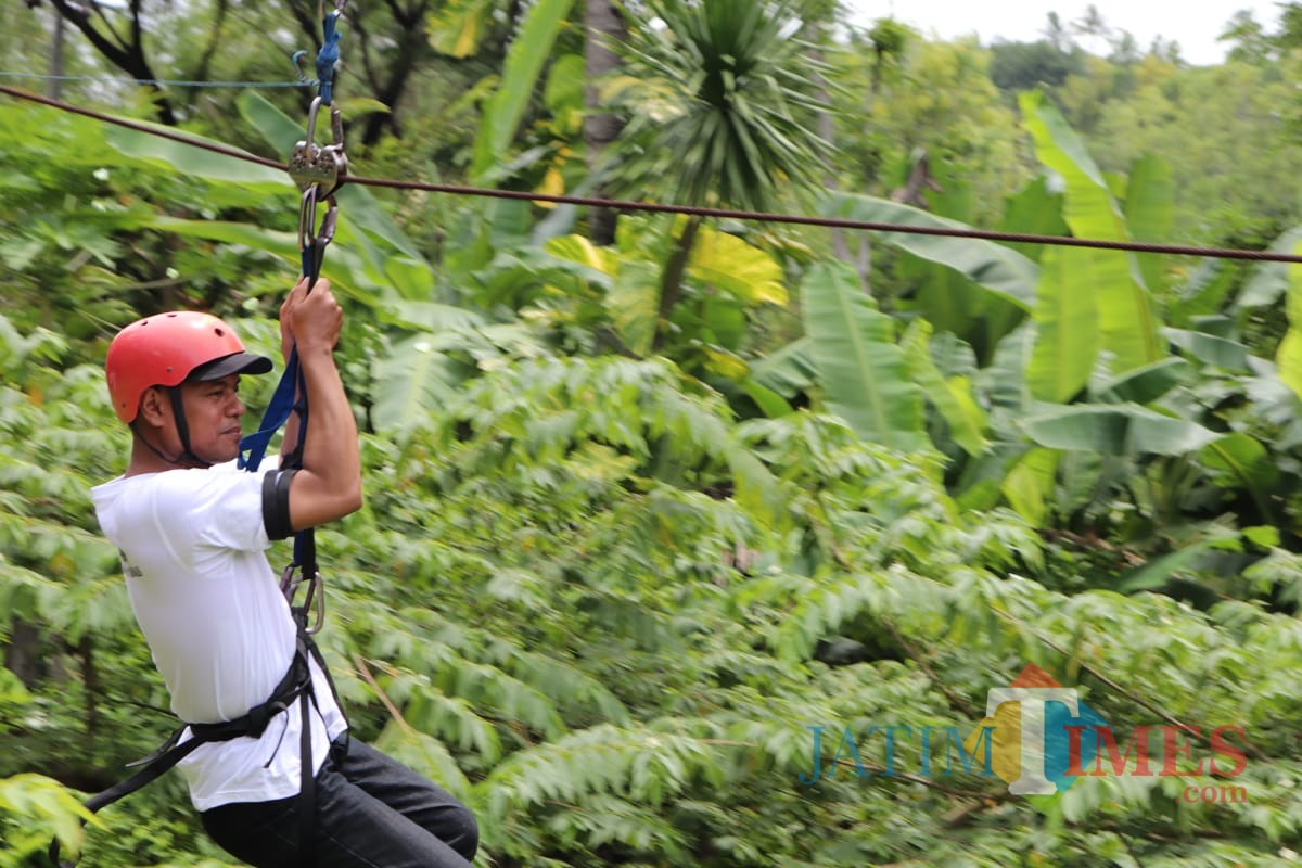 Salah satu jurnalis saat bermain flying fox (foto : Joko Pramono/Jatimtimes)0