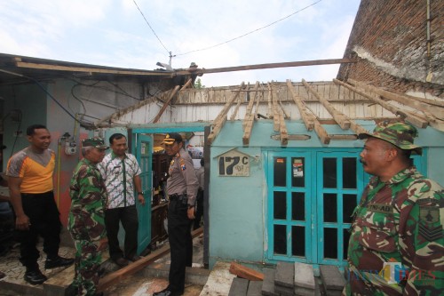 Kapolsek Mayangan Kompol Sirman, berada ditengah-tengah rumah yang roboh (Agus Salam/Jatim TIMES)