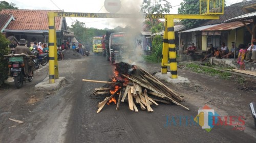 warga menutup jalan dengan cara membakar kayu dan ban bekas (Foto : Moch. R. Abdul Fatah / Jatim TlIMES)
