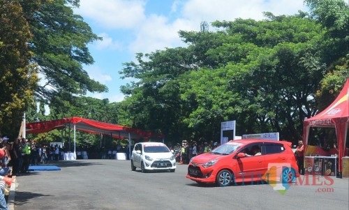 Dua mobil saling beradu drifting di Lapangan Rampal dalam rangkaian Deklarasi Millenial Road Safety Festival. (Foto: Nurlayla Ratri/MalangTIMES)