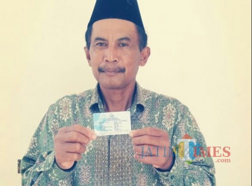 Salah satu pembudidaya ikan menerima kartu premi asuransi ikan. (eko Arif s /JatimTIMES)
