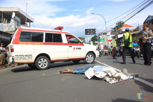 Korban tabrak lari masih tergeletak sebelum dibawa ambulans ke rumah sakit.