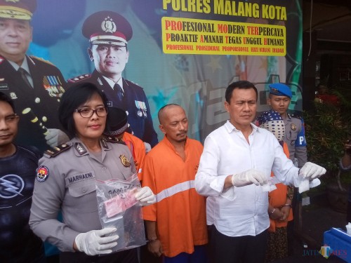Kasat Reskoba Polres Malang Kota, AKP Syamsul Hidayat saag menunjukan barang bukti bersama Kasubag Humas Polres Malang Kota, Ipda Ni Made Seruni Marhaeni (Anggara Sudiongko/MalangTIMES)