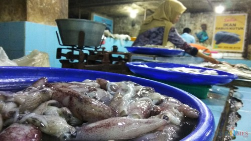 Penjual ikan laut di Pasar Besar Kota Malang tengah melayani pembeli. (Foto: Nurlayla Ratri/MalangTIMES)