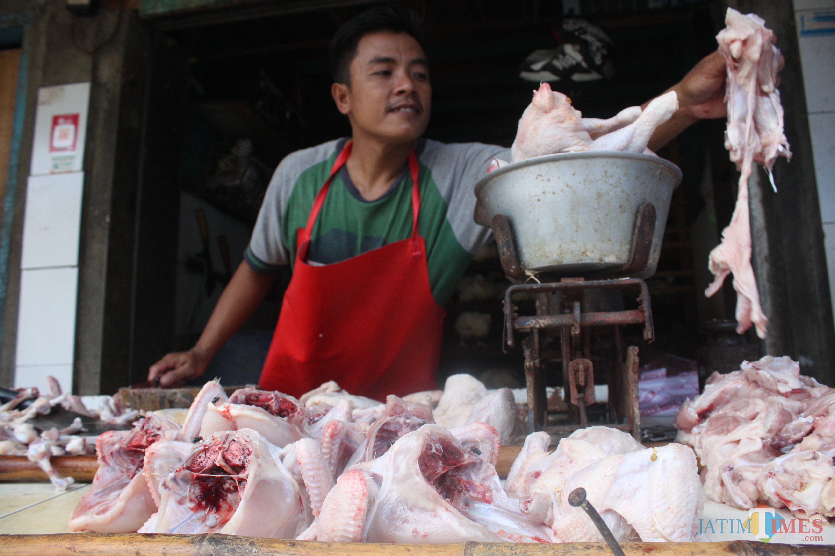 Pedagang daging ayam di Pasar Mergan menimbang daging ayam, Kamis (7/2/2019). (Luqmanul Hakim/Malang Times)
