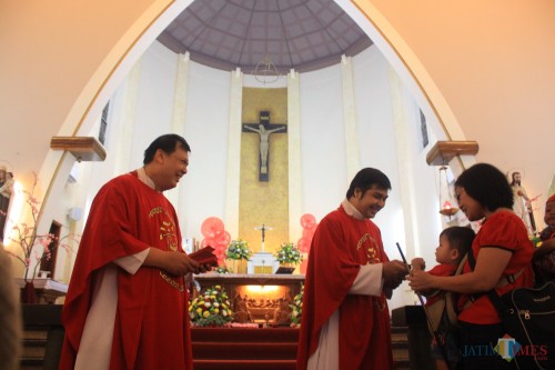 Pastor Gereja Katedral Ijen bagikan Angpao kepada jemaat anak - anak