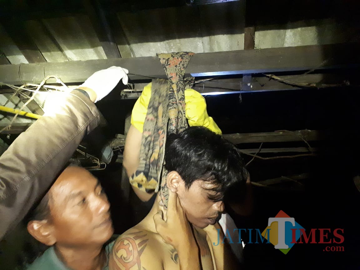 Polisi menurunkan jasad E dari kain yang digunakan gantung diri (Foto : Ist/Humas Polres Blitar Kota)