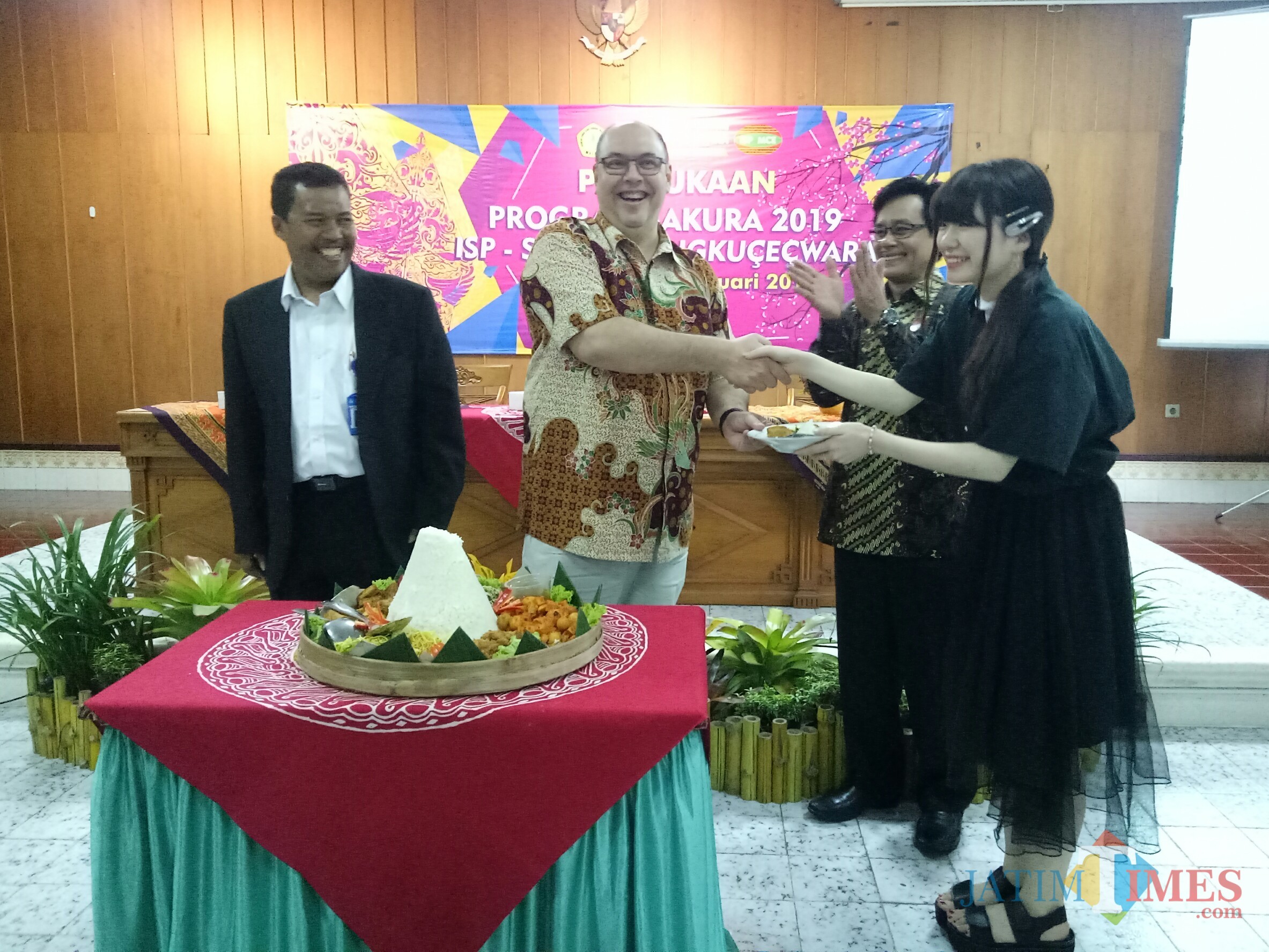 Pemberian tumpeng dari Ketua STIE Bunyamin kepada perwakilan mahasiswa Jepang (Foto: Imarotul Izzah/MalangTIMES)