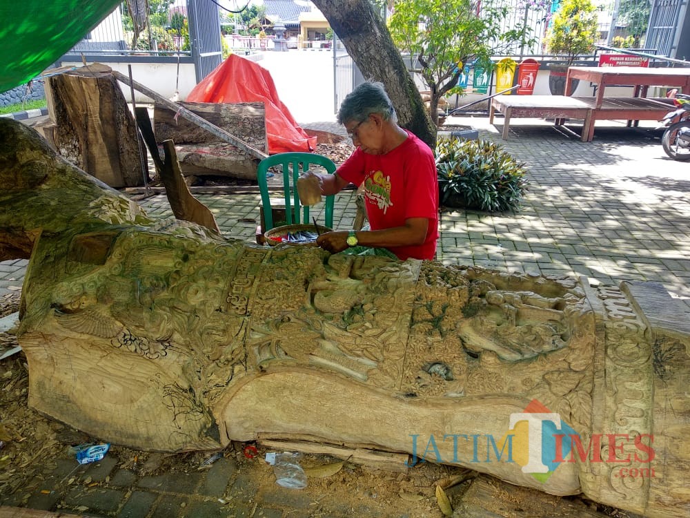 Nampak seniman sedang memahat pohon gada di Istana Gebang (Foto : Team BlitarTIMES)