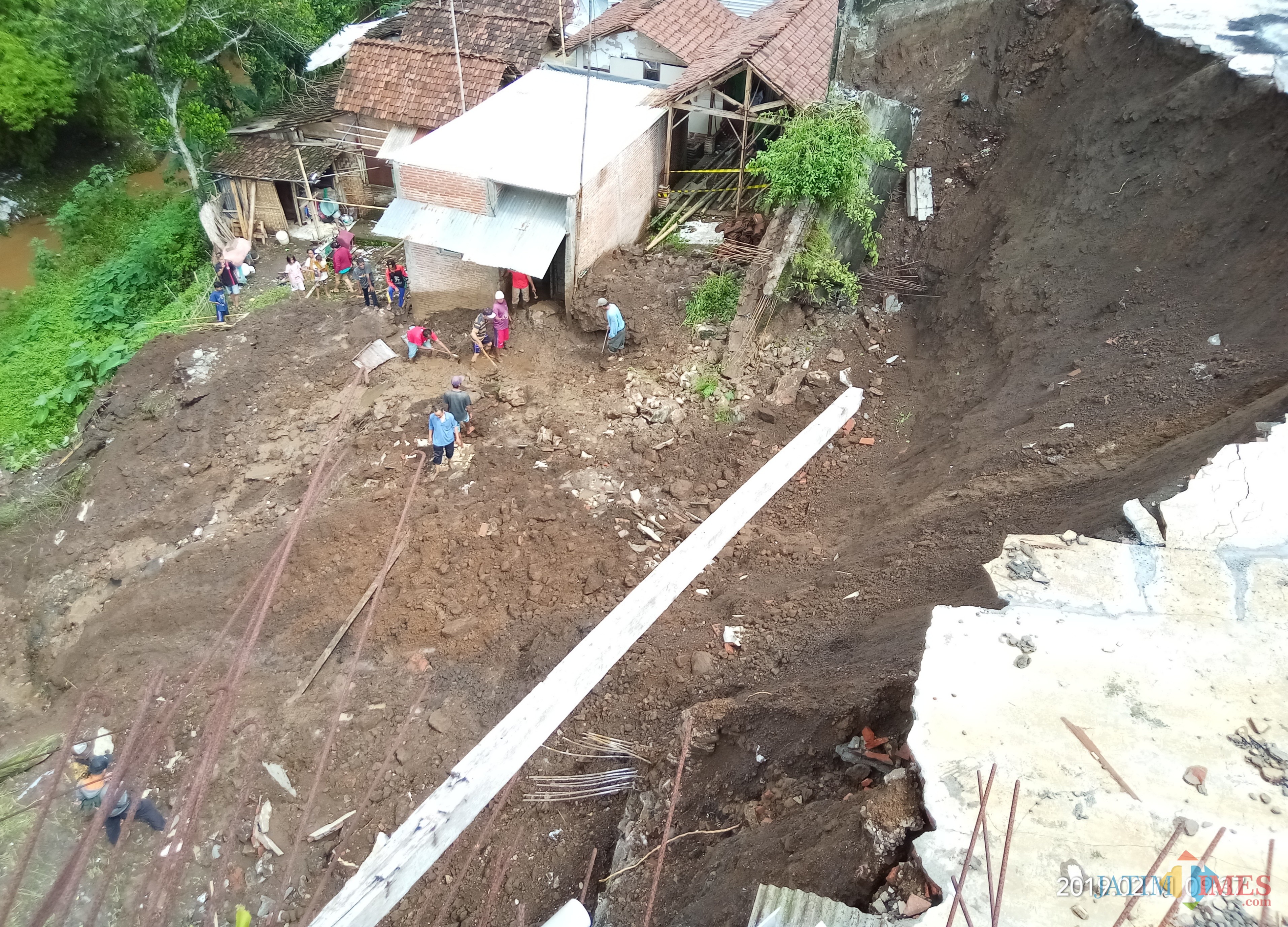 Kondisi bangunan pabrik yang longsor dan menimpa dua rumah di Pisang Candi. (Anggara Sudiongko/MalangTIMES)