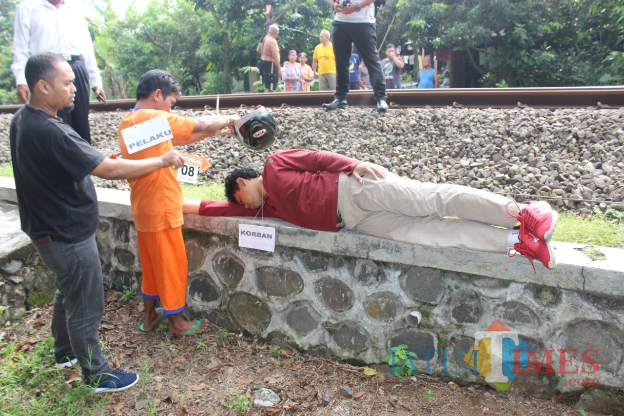 Dalam rekonstruksi, tersangka Wahyudi kepruk helm sebelum letakkan tubuh Ichwan di rel kereta api (Foto : Dokpol/ TulungagungTIMES)