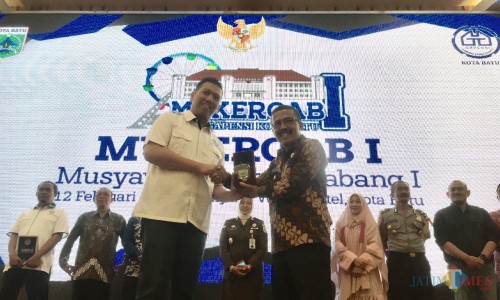 Wakil Wali Kota Batu Punjul Santoso (kanan) saat memberikan cenderamata kepada Ketua BPC Gapensi Kota Batu Hendra Angga Sonatha di di Senyum World Hotel, Kota Batu, Selasa (12/2/2019). (Foto: Irsya Richa/MalangTIMES)