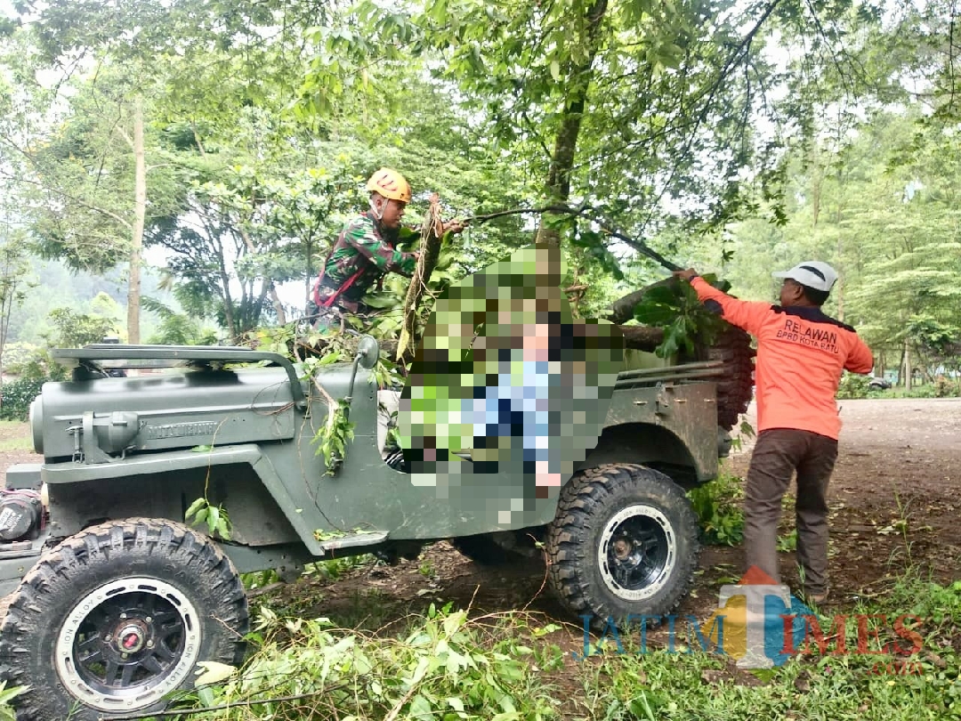 Petugas saat mengevakuasi korban terkena runtuhan pohon di Wanawisata Coban Talun, Desa Tulungrejo, Kecamatan Batu, Kamis (14/2/2019). (Foto: Irsya Richa/MalangTIMES)